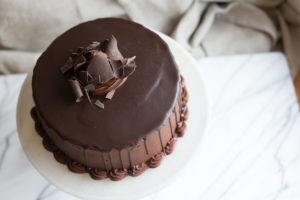 The Mad Hatter's Chocolate on Chocolate Cake with chocolate fudge icing, and dark chocolate ganache on a serving tray.