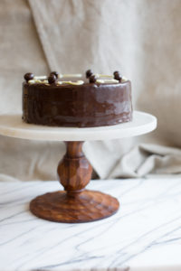 The Mad Hatter's Russian Chocolate cake coated with mocha buttercream, and poured chocolate ganache on a serving dish.