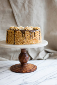 The Mad Hatter's Peanut Butter Chocolate Cake, with peanut butter buttercream and chocolate ganache on a serving dish.