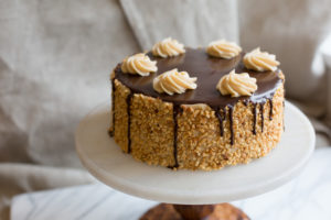 The Mad Hatter's Peanut Butter Chocolate Cake, with peanut butter buttercream and chocolate ganache on a serving dish.