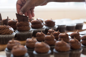 The Mad Hatter's Chocolate Cupcakes being placed on a cutting board.