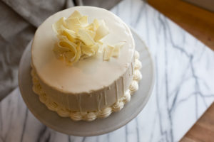 The Mad Hatter's White Lace Cake with white chocolate ganache and vanilla icing on a serving dish.