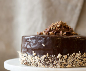 The Mad Hatter's German chocolate cake with chocolate buttercream and dark chocolate ganache on a serving dish.