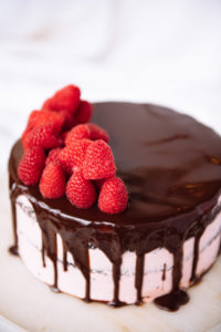 The Mad Hatter's dark chocolate with raspberry buttercream, a chocolate drizzle, and fresh raspberries.