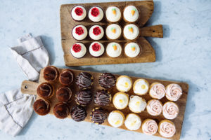 An Assortment of The Mad Hatter's Cupcakes on two wooden cutting boards.