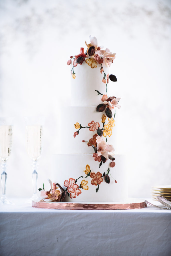 The Mad Hatter's Japanese Tea Garden wedding cake. A three tiered cake adorned with delicate flower buds and jewel tones.