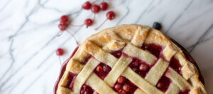 Handcrafted cherry pie with golden lattice top, signature dessert at Mad Hatter Cafe & Bakeshop