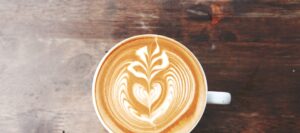 Artistic latte art with heart design on freshly brewed coffee at Mad Hatter Cafe, Durham
