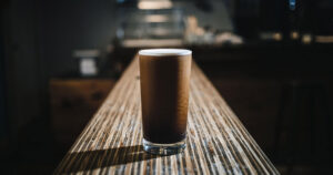 Craft nitro cold brew coffee served in a tall glass at Mad Hatter Cafe, highlighting Durham's finest local brews.