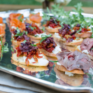 assorted gourmet appetizers, including salmon, sun-dried tomatoes, and roast beef on crostini, served at Mad Hatter Cafe & Bakeshop for parties, event, weddings in Durham