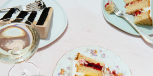 Outdoor gourmet cake tasting with vanilla and chocolate layered cakes, served on gold-rimmed plates at Mad Hatter Cafe & Bakeshop in Durham, paired with wine.