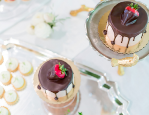 Elegant dessert display with cakes, fruit, and appetizers from Mad Hatter's catering in Durham