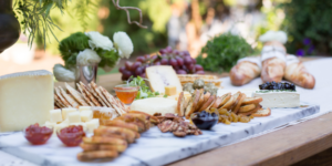 Gourmet cheese board with assorted cheeses, nuts, and crackers from Mad Hatter's catering in Durham