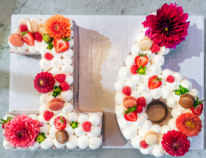 16th birthday cake from Mad Hatter's Durham Bakery decorated with flowers and macarons