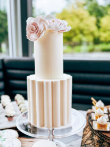 Elegant wedding cake with buttercream design and floral accents on display stand