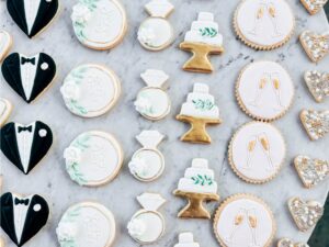 An assortment of wedding-themed cookies tastefully displayed on a marble countertop.